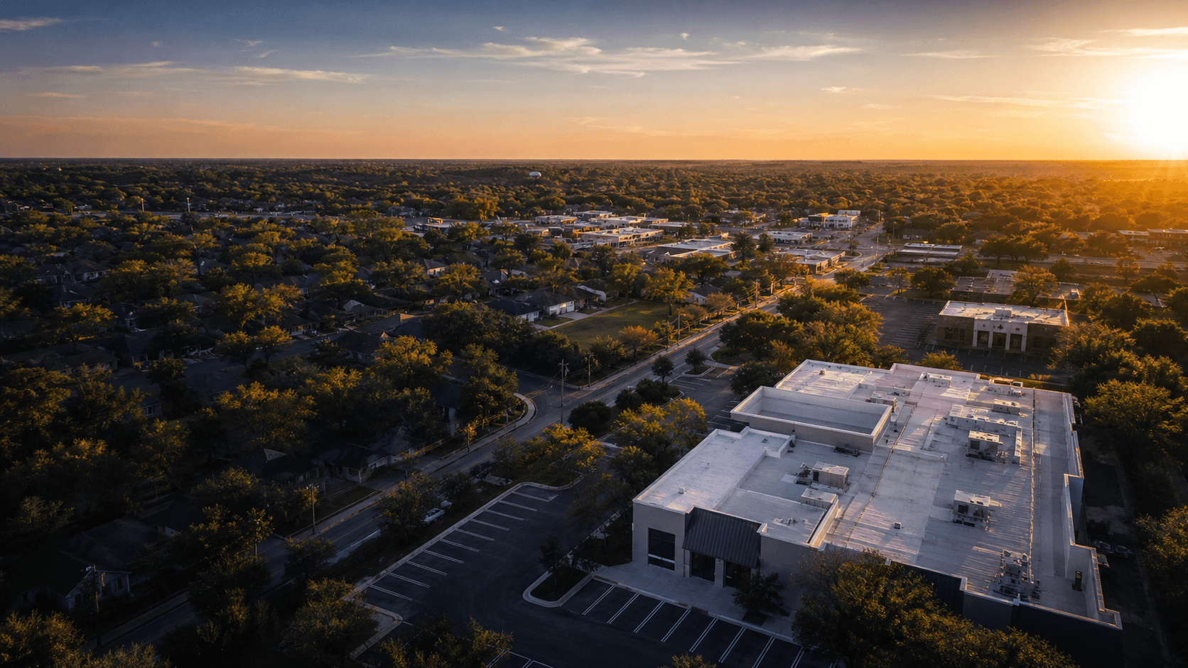 Aerial view of a Central Indiana neighborhood and commercial property at sunset